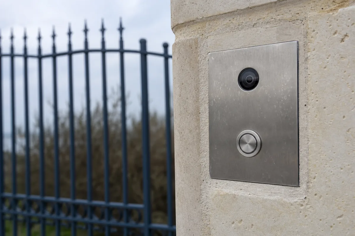 Platine de visiophone en inox fixée sur un pilier de portail, maison de bord de mer